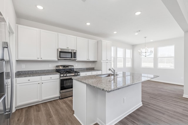 800 Heritage Blvd, Delaware, OH 43015 - kitchen featuring wood finished floors, white cabinets, light stone counters, a sink, and stainless steel appliances