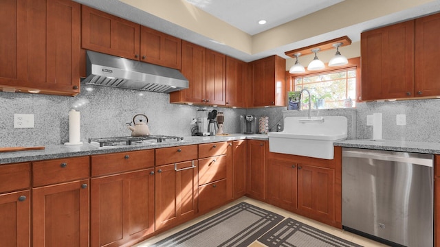 kitchen with backsplash, sink, stainless steel appliances, and decorative light fixtures