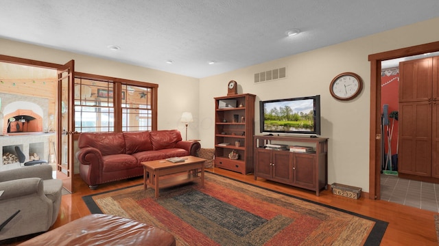 living room featuring a textured ceiling and light wood-type flooring