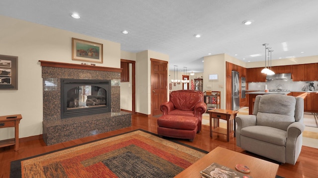 living room featuring a premium fireplace, a textured ceiling, and light wood-type flooring