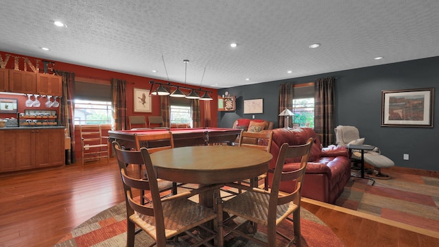 dining area featuring plenty of natural light, dark hardwood / wood-style flooring, a textured ceiling, and pool table