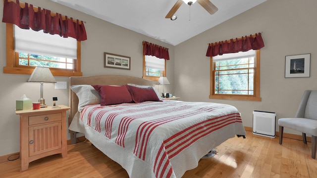 bedroom with light wood-type flooring, multiple windows, lofted ceiling, and ceiling fan