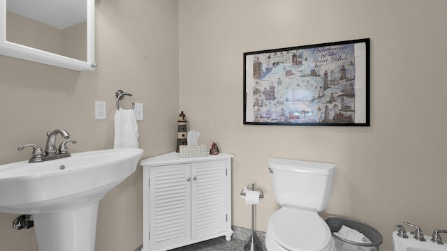 bathroom with toilet, a bidet, and sink