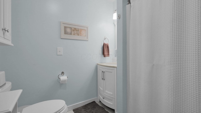 bathroom with a shower with shower curtain, vanity, and toilet