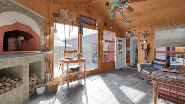 interior space featuring ceiling fan, wood walls, wood ceiling, and high vaulted ceiling