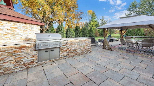 view of patio / terrace featuring a gazebo, grilling area, and exterior kitchen