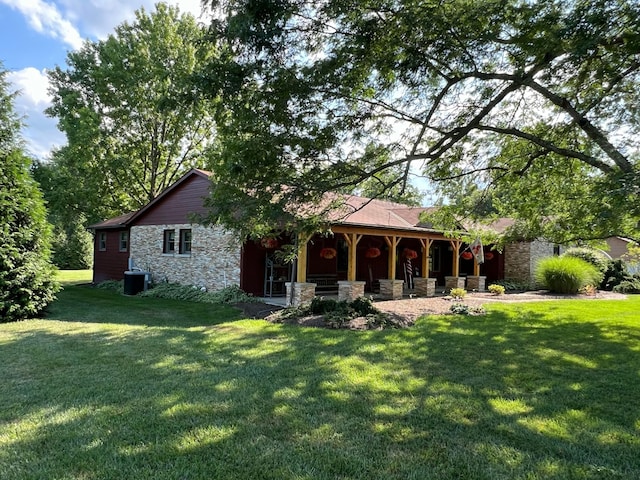 back of house with a yard and central AC