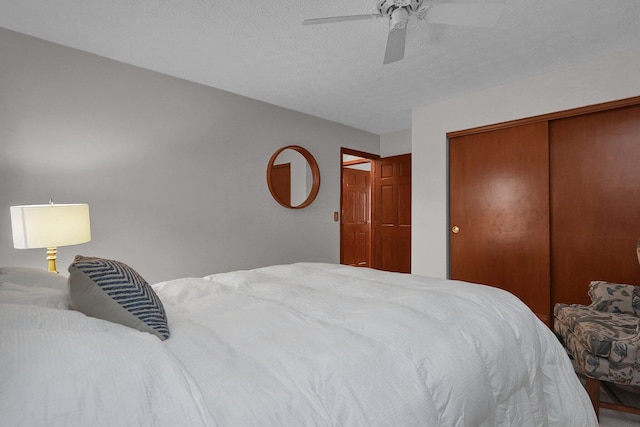 bedroom featuring a ceiling fan, a closet, and a textured ceiling