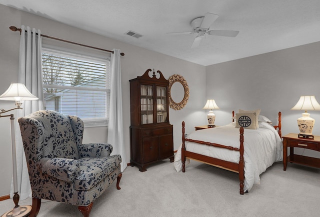 bedroom with ceiling fan, visible vents, and light colored carpet