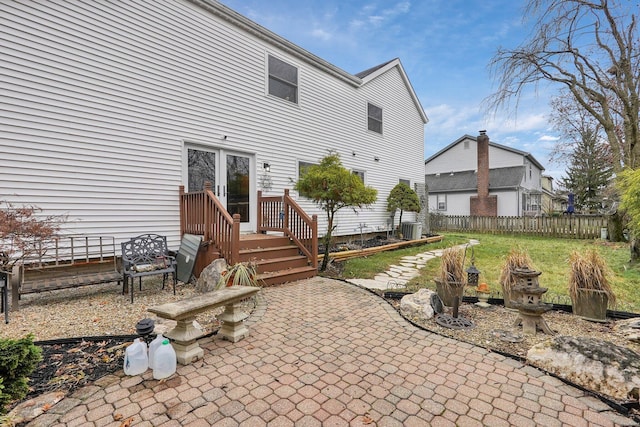 back of property with a lawn, central AC, fence, and a patio area