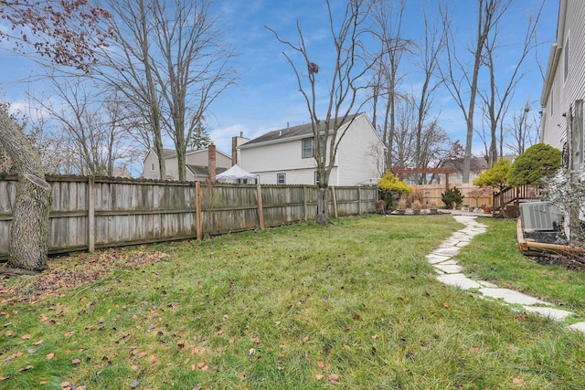 view of yard with a fenced backyard and central AC unit