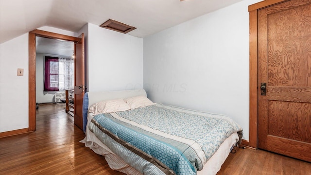 bedroom with dark hardwood / wood-style floors and vaulted ceiling