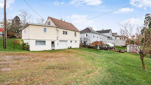 back of house featuring a yard and a garage