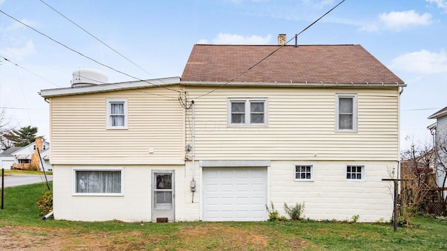 back of house with a lawn and a garage