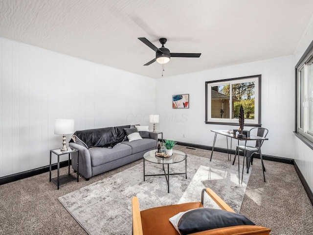 carpeted living room with ceiling fan and a textured ceiling