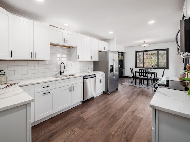 kitchen featuring decorative backsplash, appliances with stainless steel finishes, dark wood-type flooring, sink, and white cabinetry