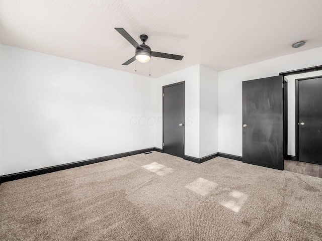 unfurnished bedroom featuring ceiling fan, light colored carpet, and a textured ceiling