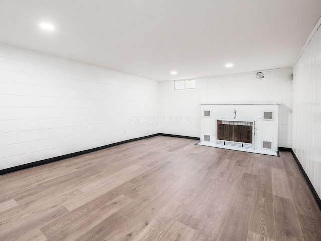 unfurnished living room featuring a fireplace and light hardwood / wood-style flooring