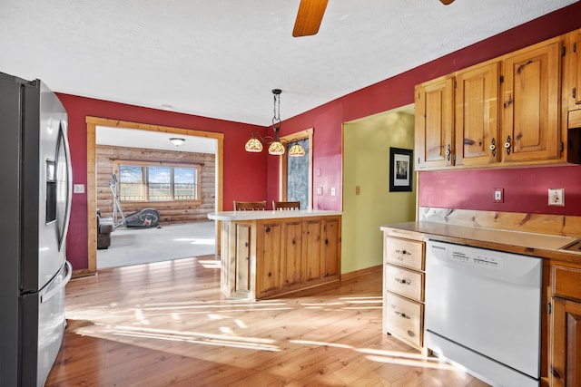 kitchen featuring white dishwasher, light hardwood / wood-style flooring, a textured ceiling, decorative light fixtures, and stainless steel fridge with ice dispenser