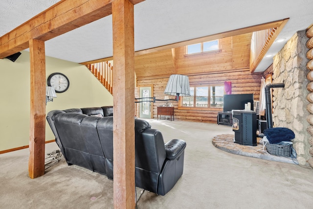 living room featuring a wood stove, light colored carpet, and a textured ceiling