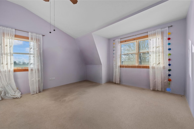 additional living space featuring plenty of natural light, light colored carpet, and vaulted ceiling