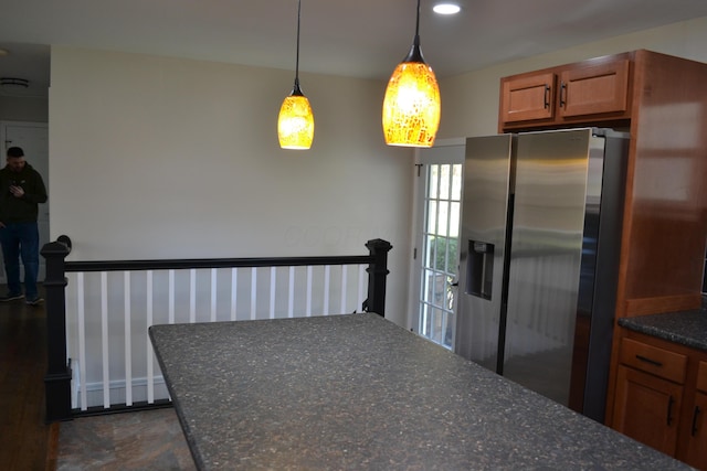 kitchen featuring pendant lighting and stainless steel refrigerator with ice dispenser