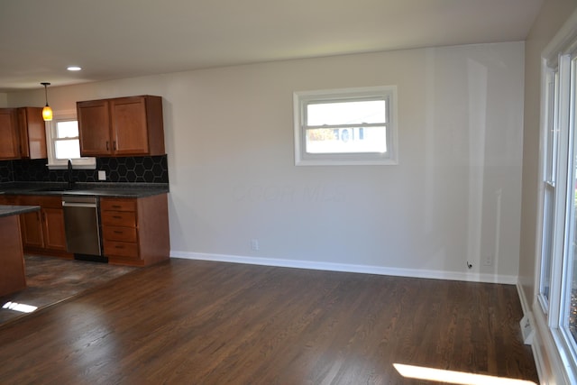 kitchen with dishwasher, dark hardwood / wood-style floors, tasteful backsplash, and a healthy amount of sunlight