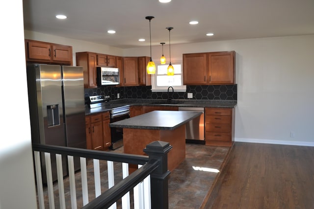 kitchen with dark hardwood / wood-style flooring, stainless steel appliances, sink, a center island, and hanging light fixtures