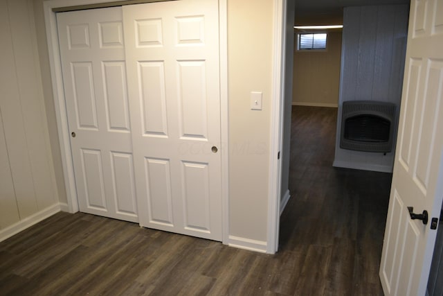 hall with heating unit, wood walls, and dark wood-type flooring