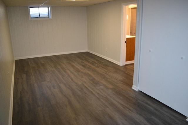 basement featuring wood walls and dark wood-type flooring