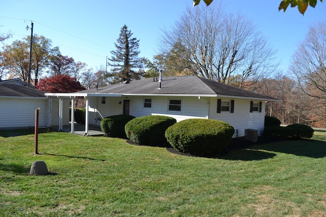 back of house featuring central air condition unit and a yard