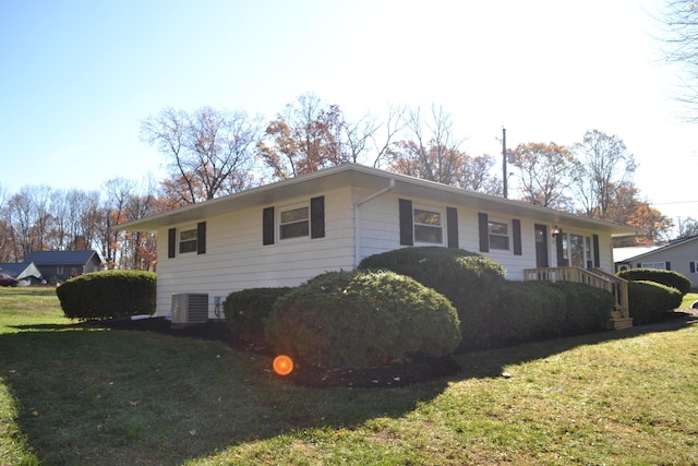 ranch-style home with central air condition unit and a front lawn