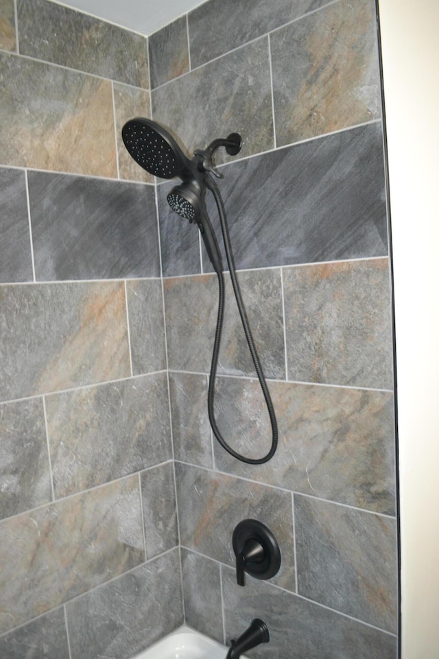 room details with tiled shower / bath combo