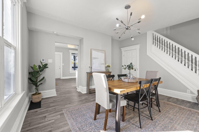 dining area with a notable chandelier, dark wood-type flooring, and a wealth of natural light