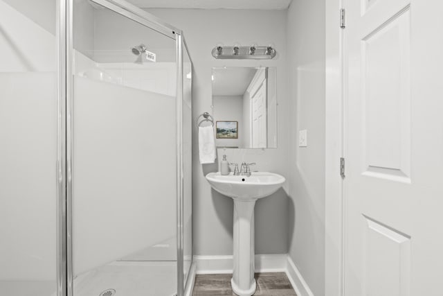 bathroom featuring hardwood / wood-style flooring and a shower with door