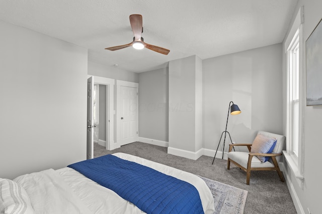 carpeted bedroom featuring ceiling fan and a textured ceiling