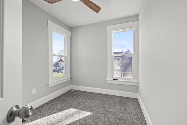 carpeted spare room featuring plenty of natural light and ceiling fan