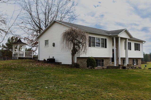 view of side of property featuring a gazebo, central air condition unit, and a lawn