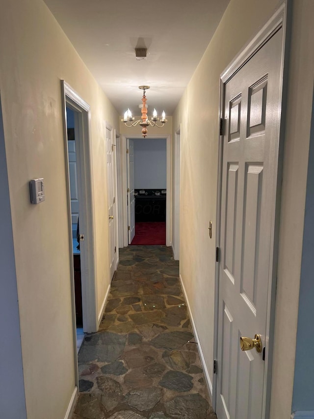 hallway featuring an inviting chandelier