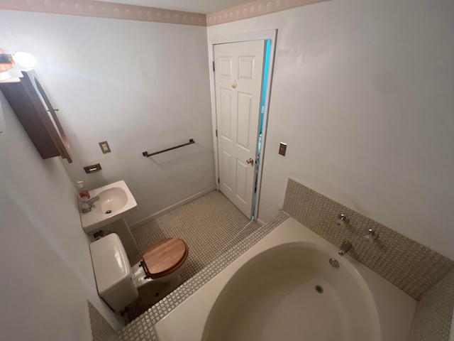 bathroom featuring sink, a bathtub, and toilet