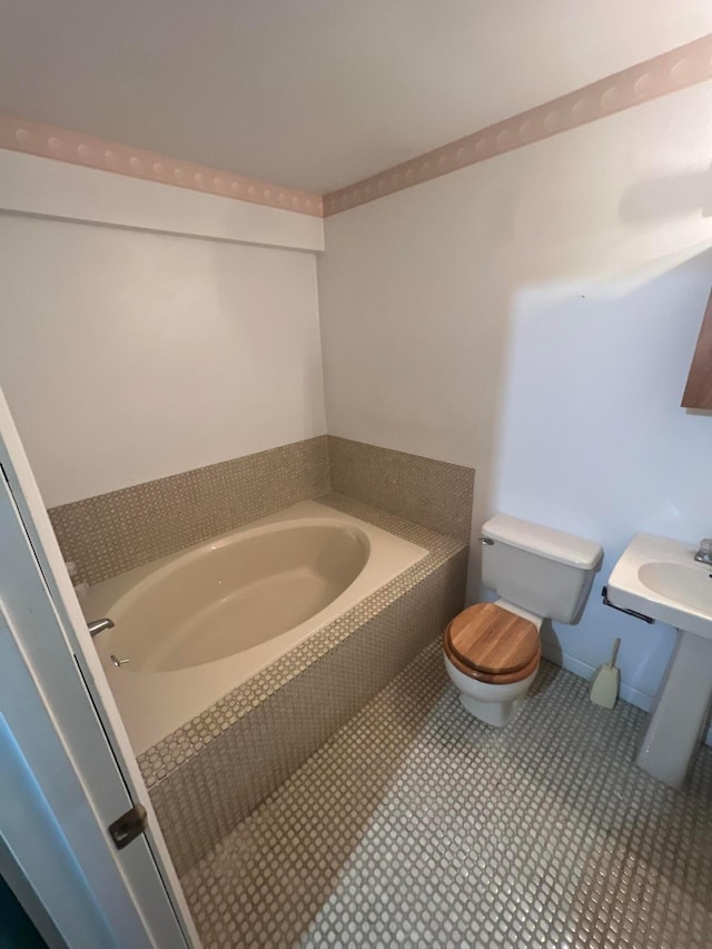 bathroom with toilet and tiled bath