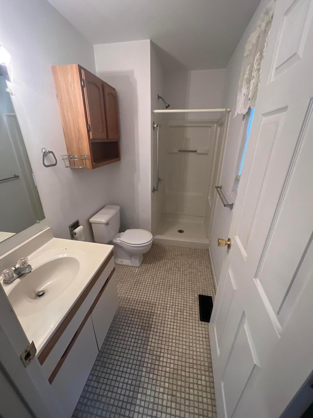 bathroom featuring tile patterned floors, toilet, vanity, and a shower