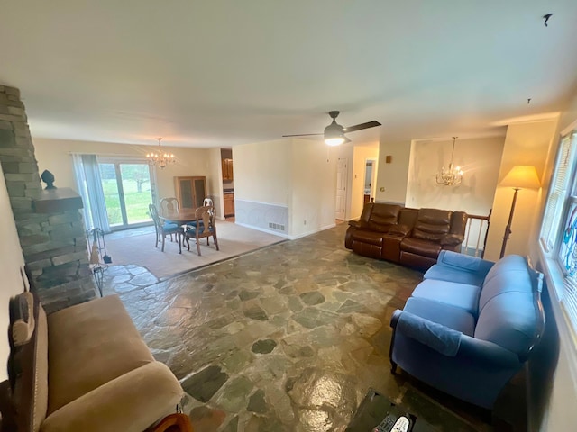 living room with ceiling fan with notable chandelier