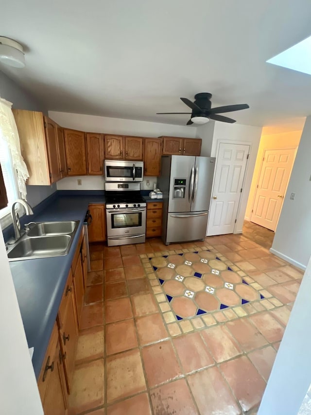 kitchen featuring stainless steel appliances, light tile patterned flooring, sink, and ceiling fan