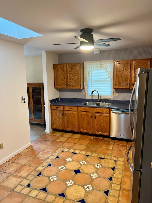 kitchen with appliances with stainless steel finishes, sink, light tile patterned floors, and ceiling fan