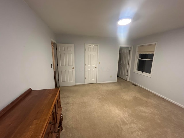 unfurnished bedroom featuring light carpet