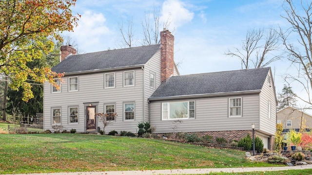 colonial home with a garage and a front lawn