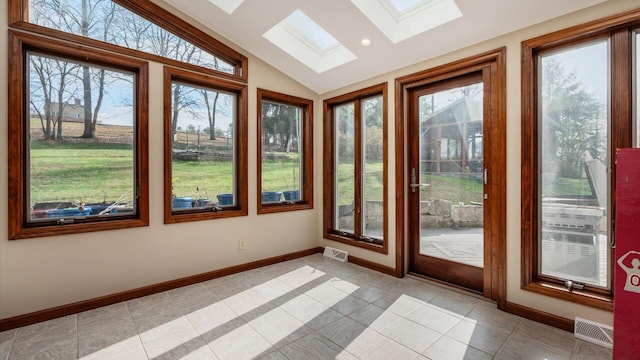 unfurnished sunroom featuring a wealth of natural light and vaulted ceiling with skylight