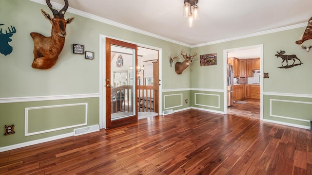 spare room featuring dark hardwood / wood-style floors and ornamental molding