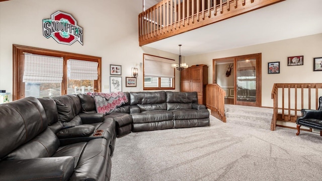 carpeted living room featuring a towering ceiling and a chandelier